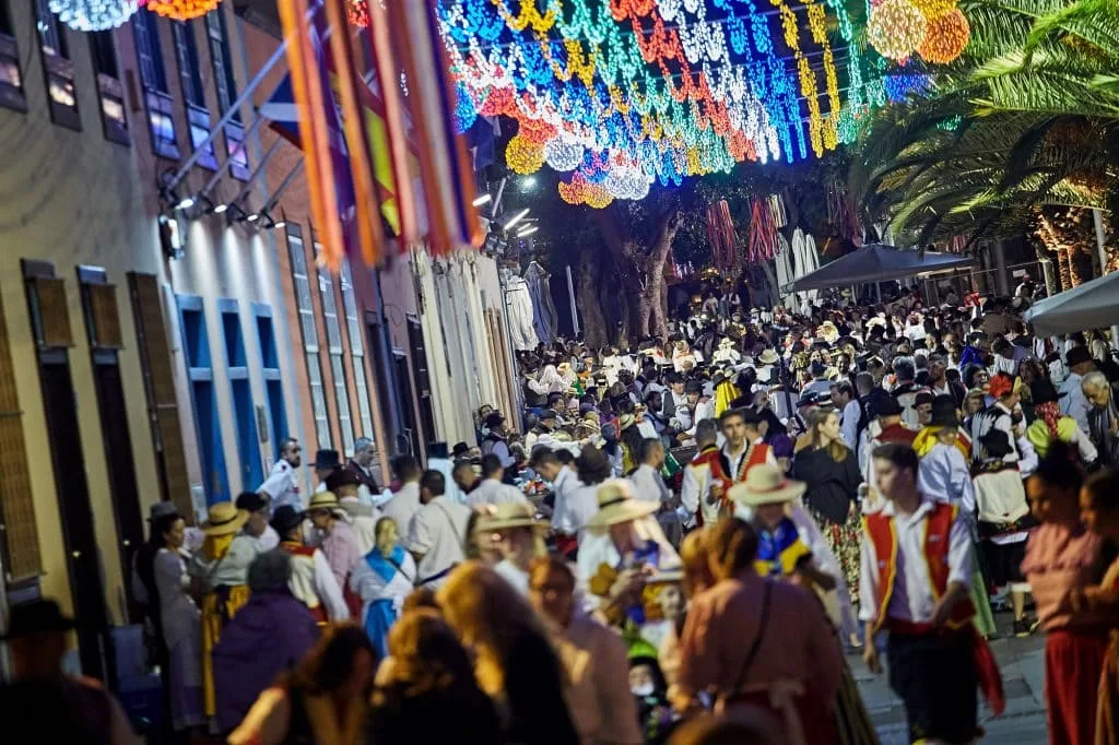 Ambiente nocturno en las Fiestas de Mayo con trajes canarios y luces de colores
